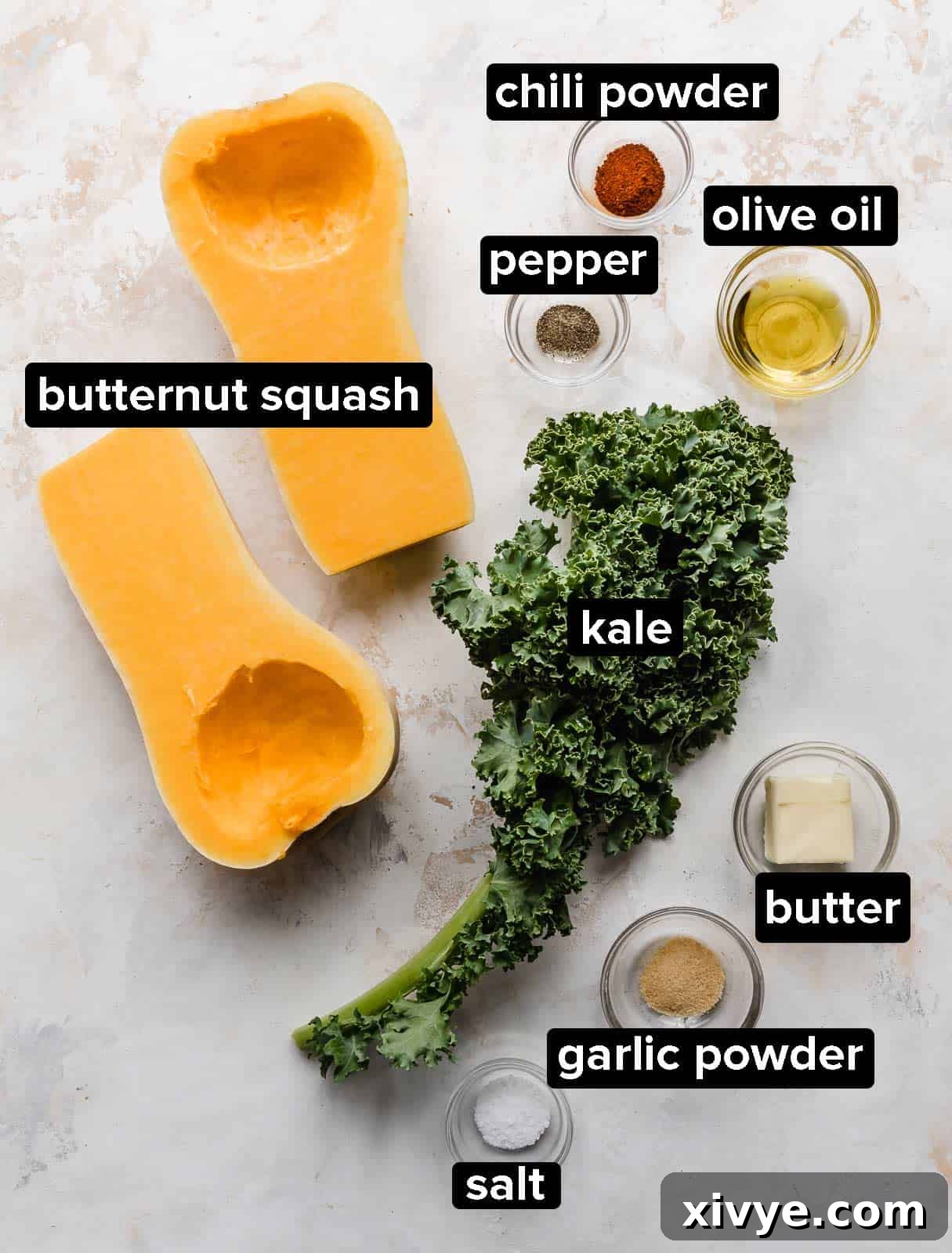 Butternut Squash and Kale Delight 3 Ingredients used to make a butternut squash and kale dish, beautifully arranged on a white textured background.