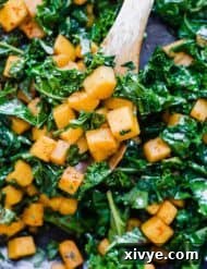 A close up photo of cubed Butternut Squash and Kale, perfectly cooked and seasoned.