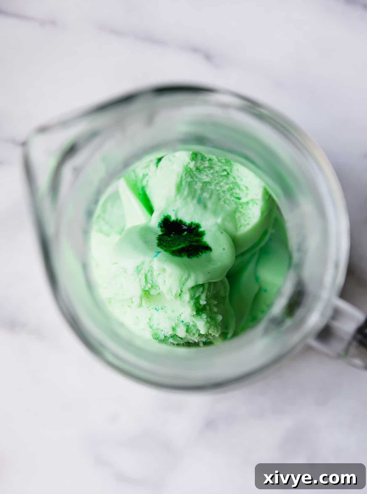 Identity Shifter Brew 4 Overhead photo of lime sherbet and a drop of green food color in a glass pitcher.