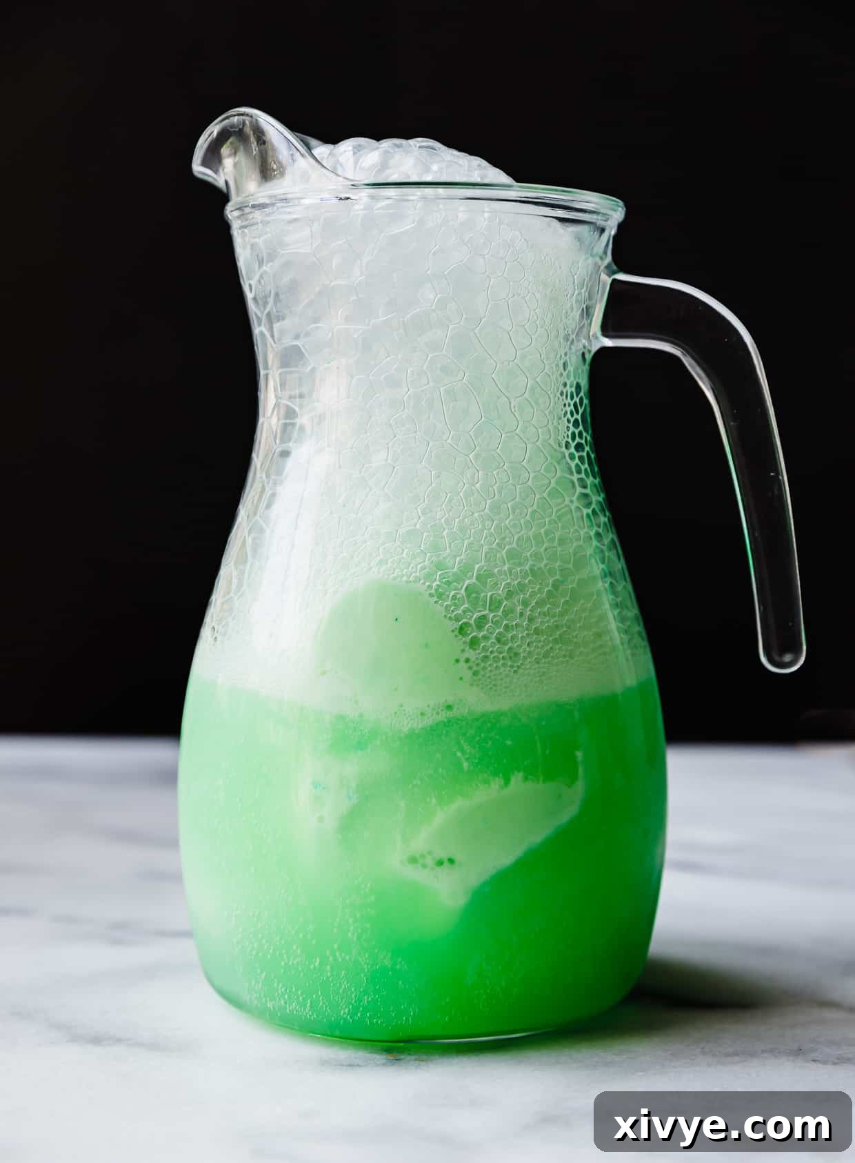 Identity Shifter Brew 5 A glass pitcher filled with vibrant green Polyjuice Potion, ready to be served.