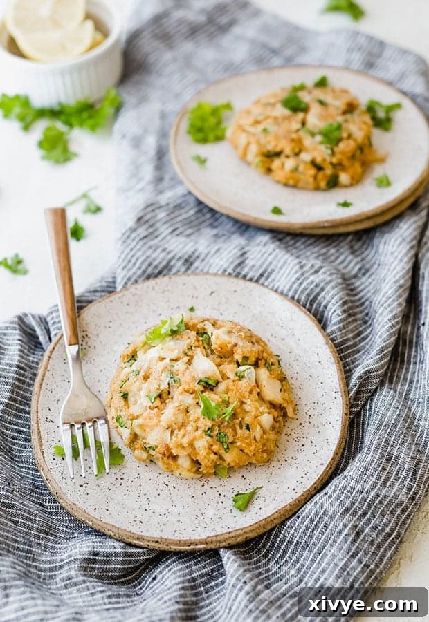 Crispy Tilapia Patties 7 A single tilapia cake on a small, elegant plate, topped with fresh chopped parsley, with a fork resting beside it, ready to be enjoyed.
