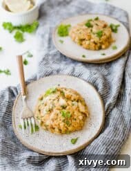 A beautifully presented tilapia cake on a plate, resting on a blue linen napkin.