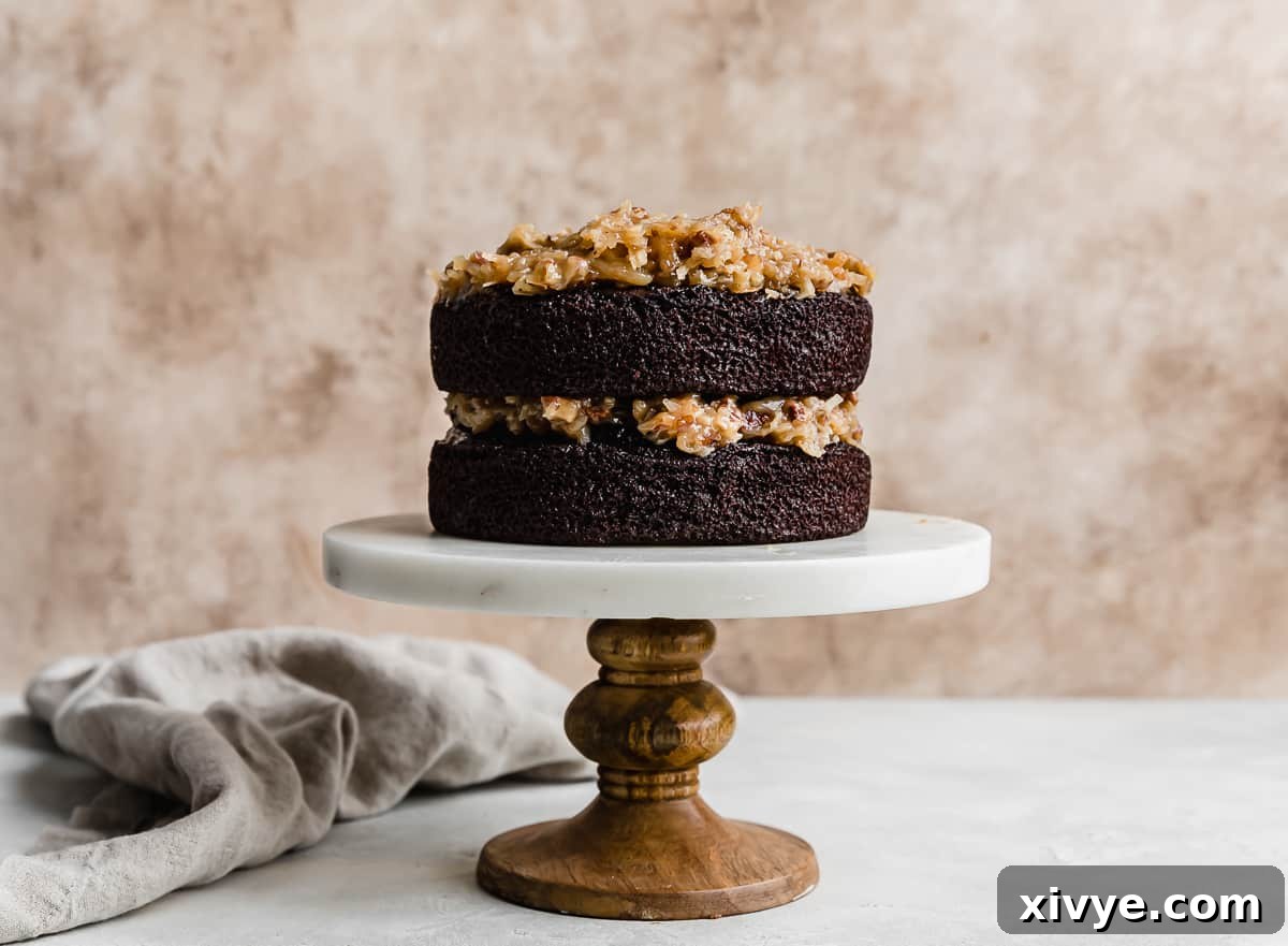 A tempting photo of a two-layer German Chocolate Cake, generously filled with a rich coconut pecan frosting between the layers, hinting at its moist texture.