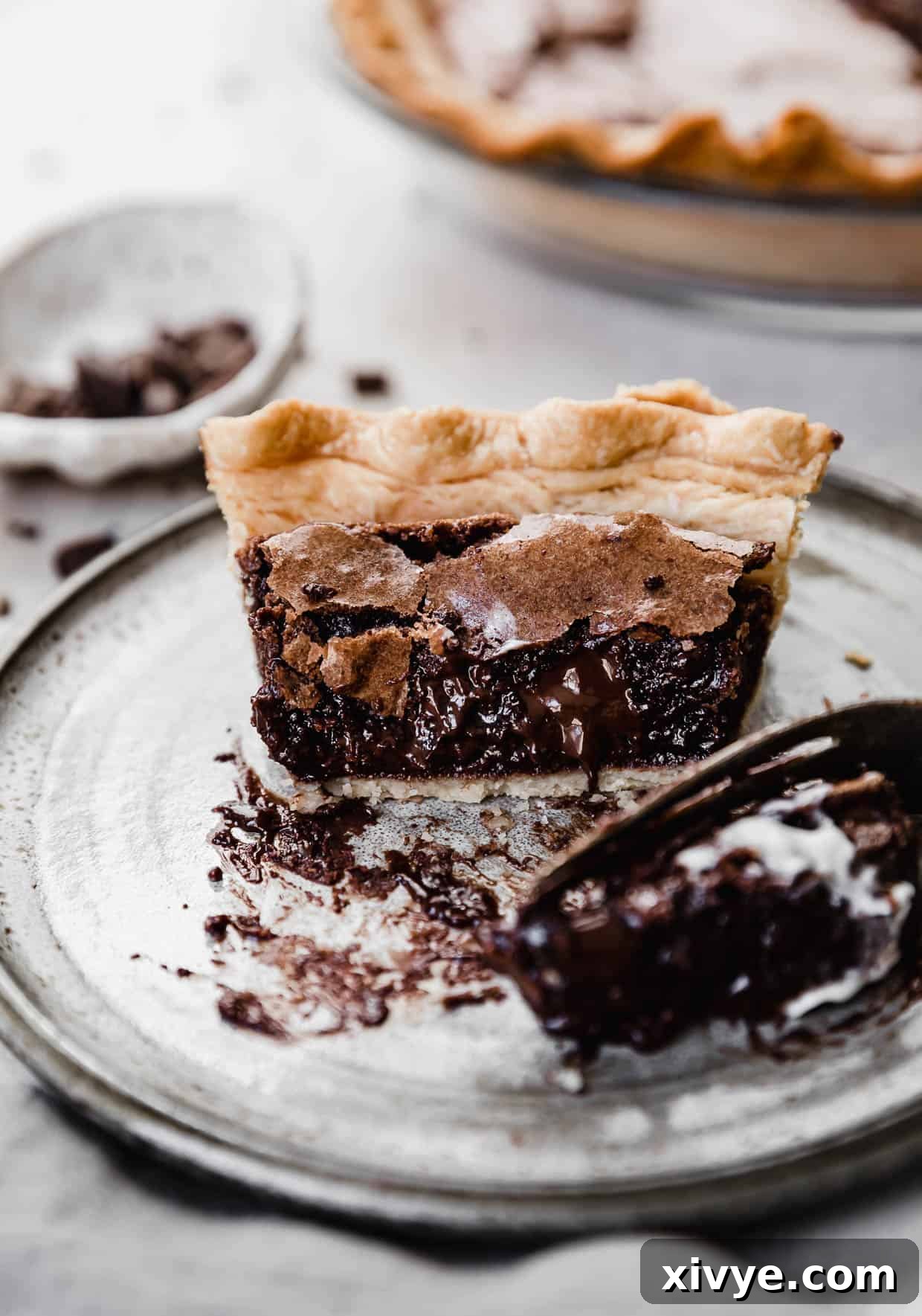 A brownie pie with a fork cutting into it showing melty chocolate.