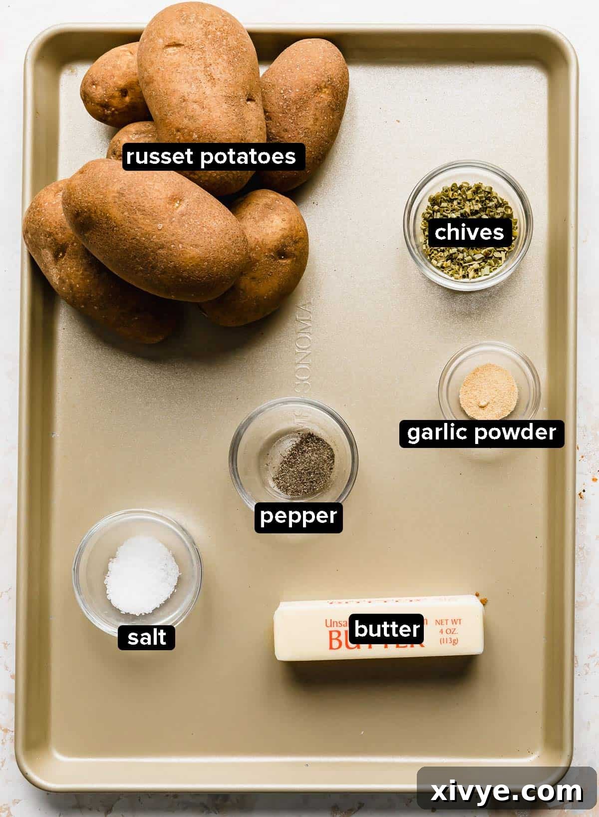 Crispy Air-Fried Hasselback Potatoes 2 Hasselback Potatoes ingredients on a bronze baking sheet.