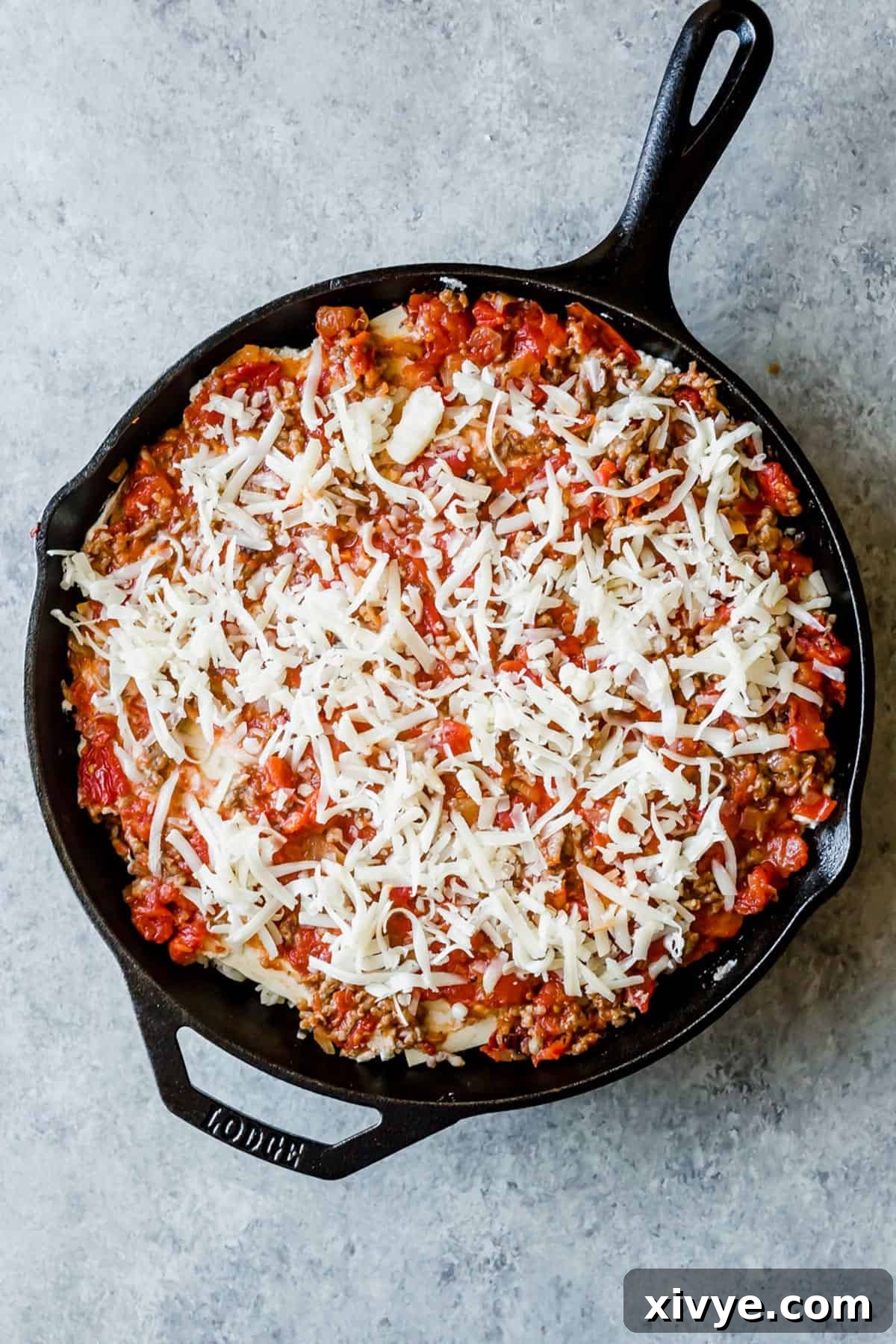 A Cast Iron Lasagna topped with abundant mozzarella cheese, ready for baking.