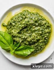 Fresh basil pesto in a serving bowl with a spoon