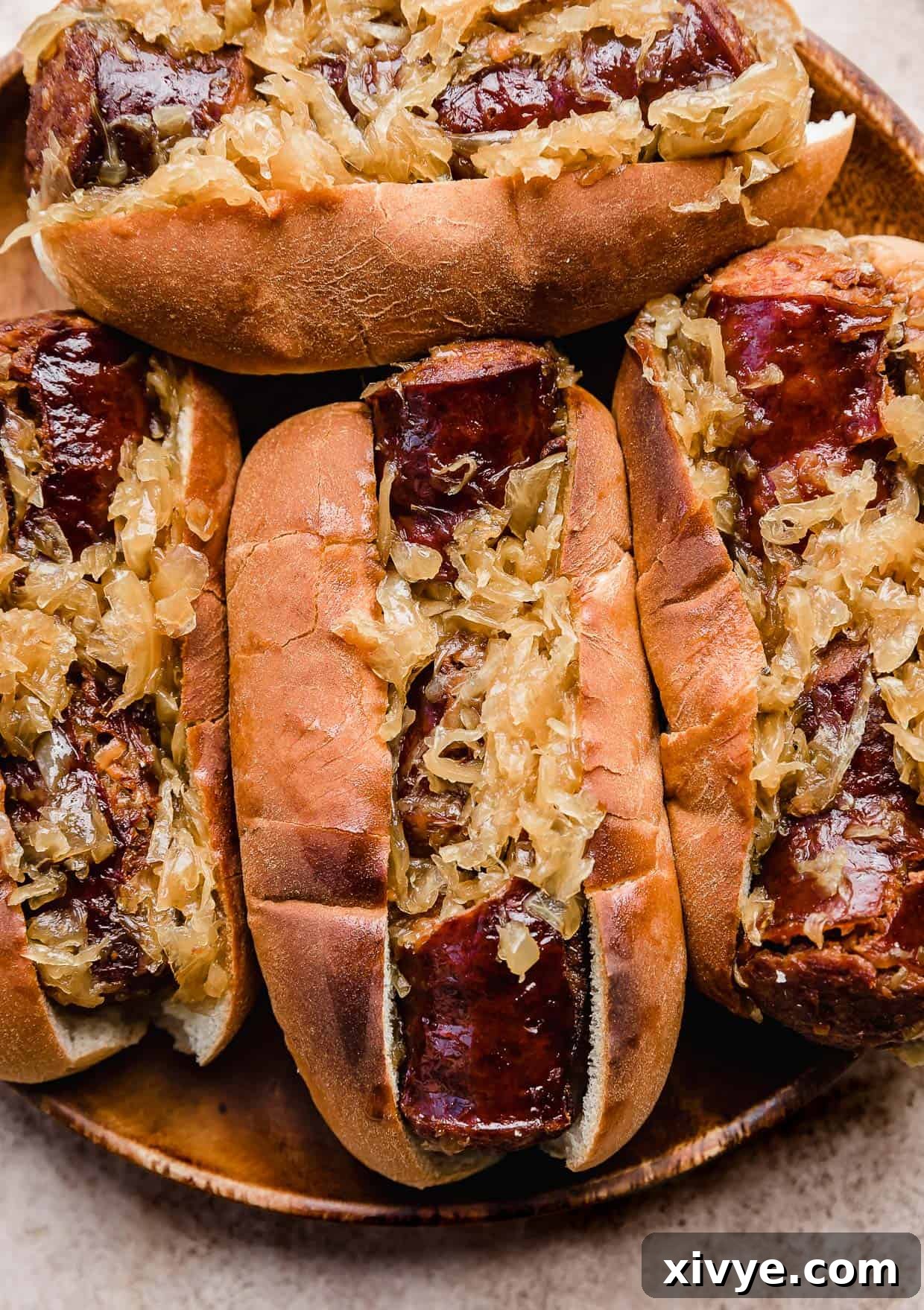 Slow cooker kielbasa and sauerkraut served on toasted buns with a side of potato wedges.