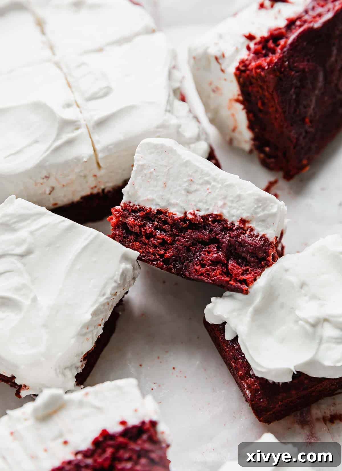 A Red Velvet Brownie topped with cream cheese whipped cream frosting.