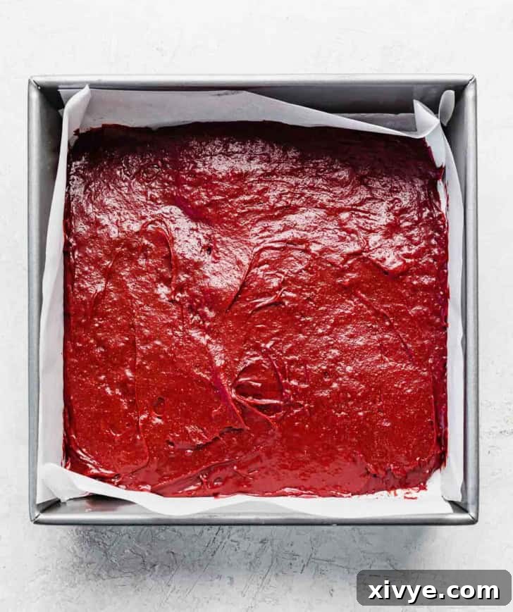 Red velvet brownie batter in a square pan.