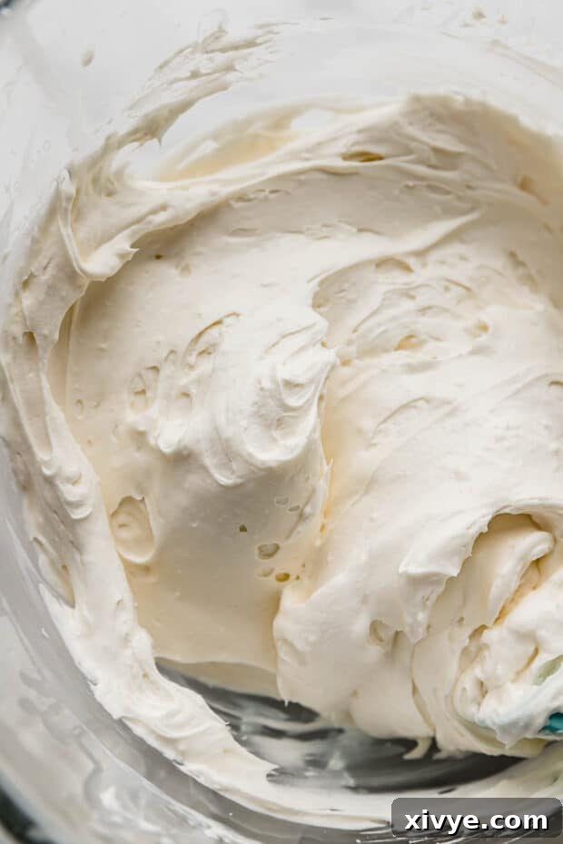 A close up of Cream Cheese Whipped Cream Frosting in a glass bowl.