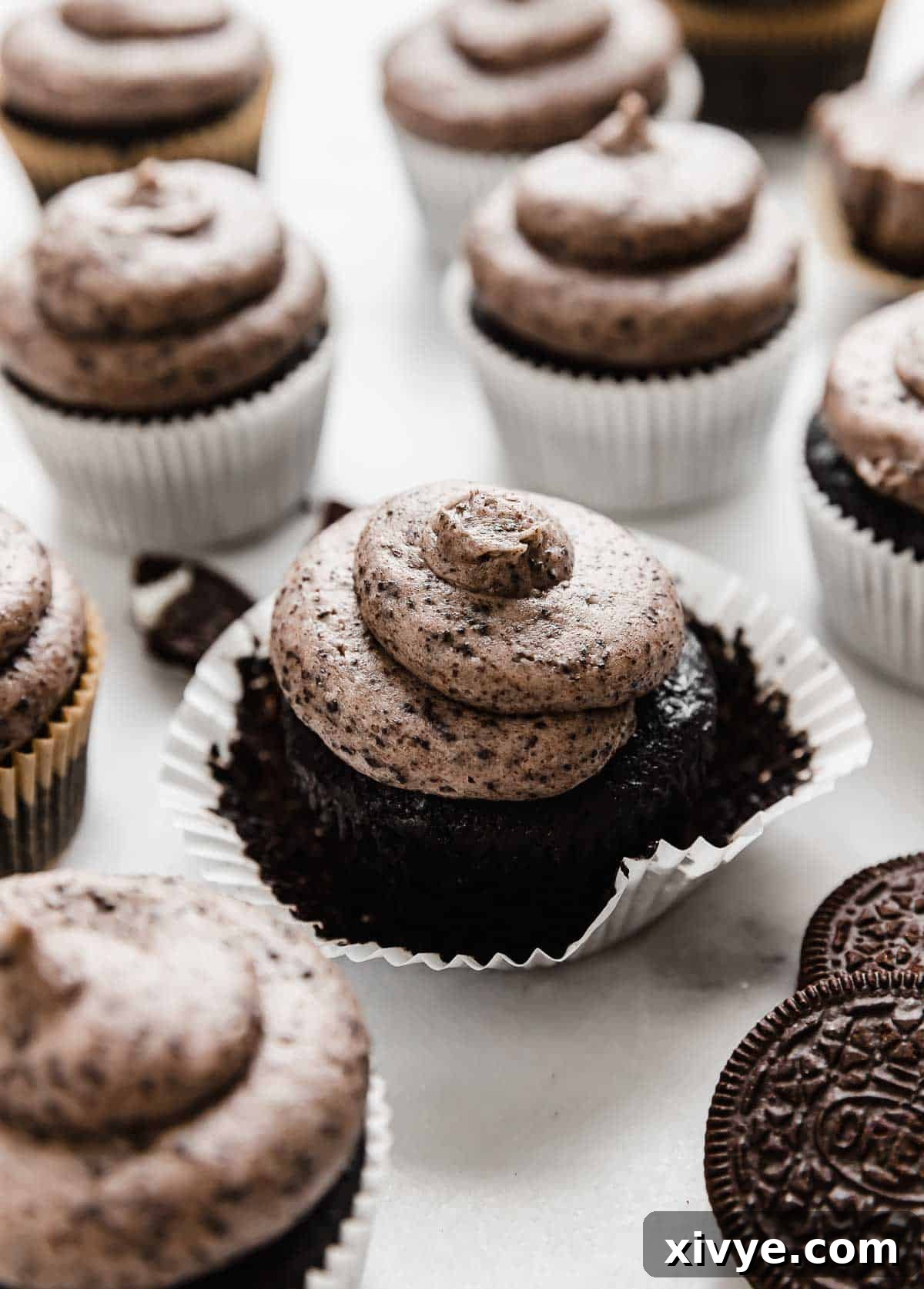 Delightful Oreo Cupcakes arranged on a pristine white background, each adorned with an elegant swirl of rich Oreo frosting and a mini Oreo garnish.