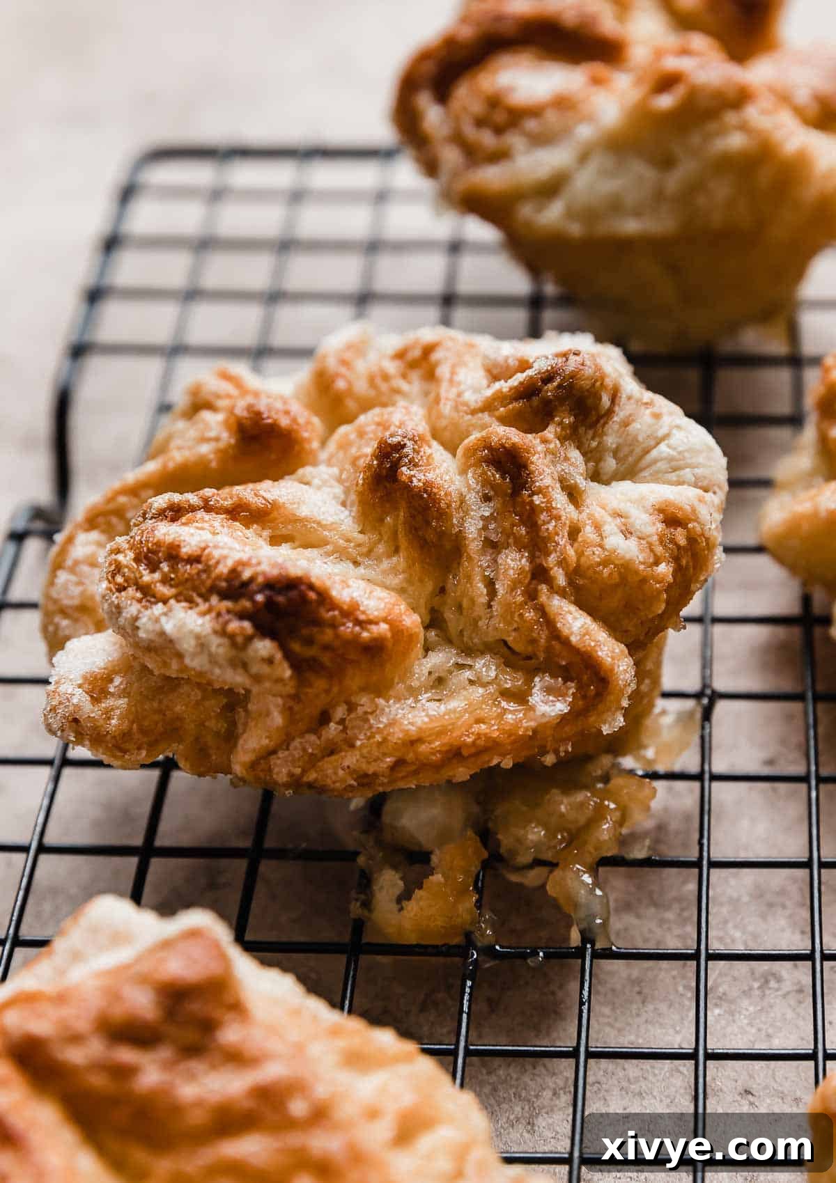 A homemade Kouign-Amann pastry on a black cooling rack.