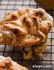 A baked Kouign-Amann on a black cooling rack.