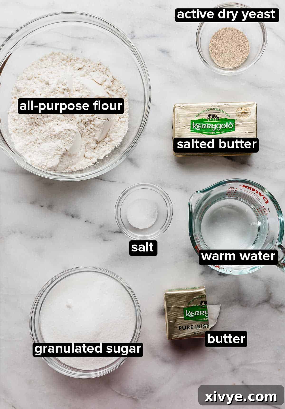 Kouign-Amann ingredients portioned in glass bowls on a white marble table.