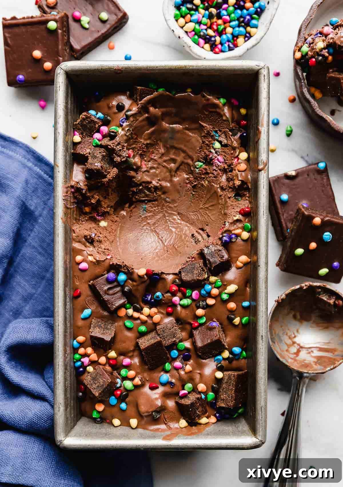 Stardust Brownie Galaxy 8 Cosmic Brownie Ice Cream in a silver bread pan with a scoop of ice cream missing from the pan.