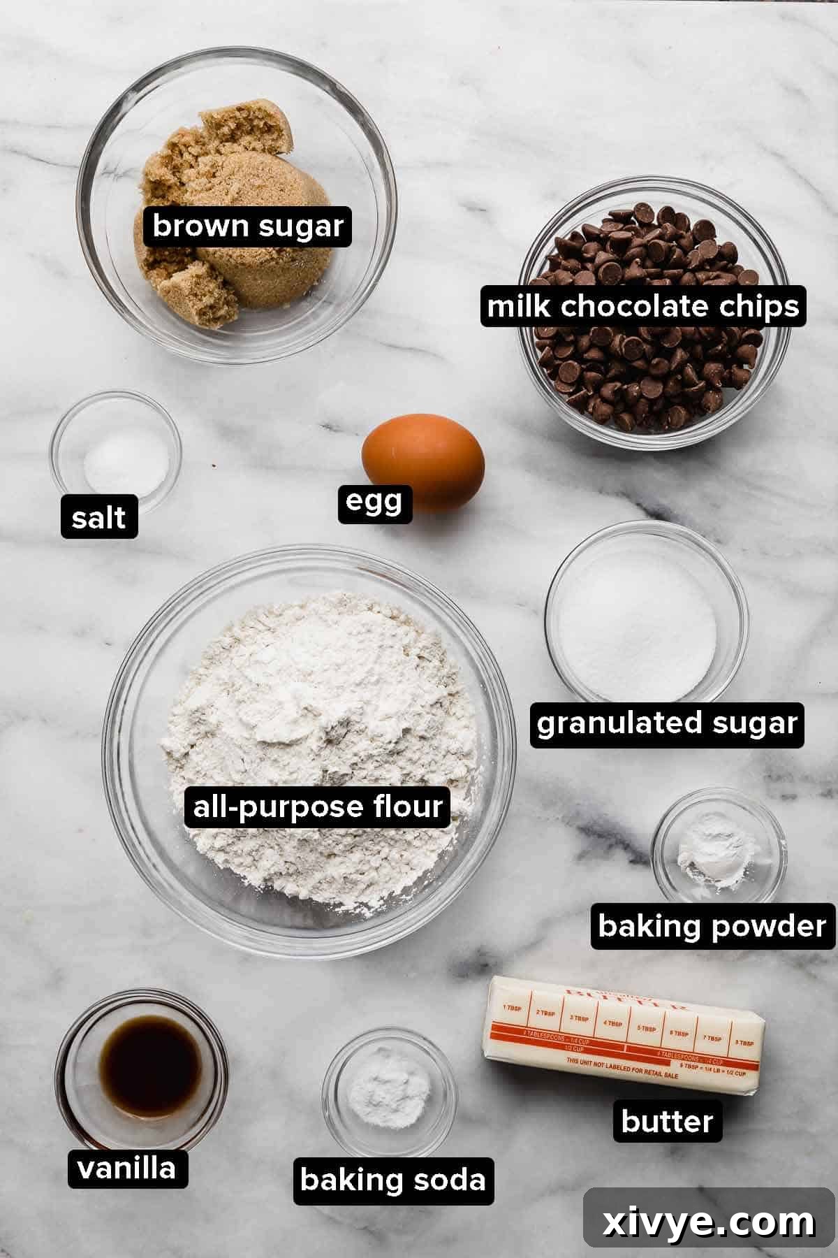 Homemade Milk Chocolate Chip Perfection 3 All the necessary ingredients for Milk Chocolate Chip Cookies, neatly portioned into glass bowls and arranged on a elegant white marbled background, ready for baking.