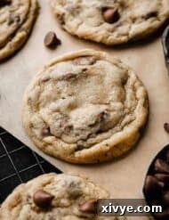 A milk chocolate chip cookie on a black wire cooling rack.