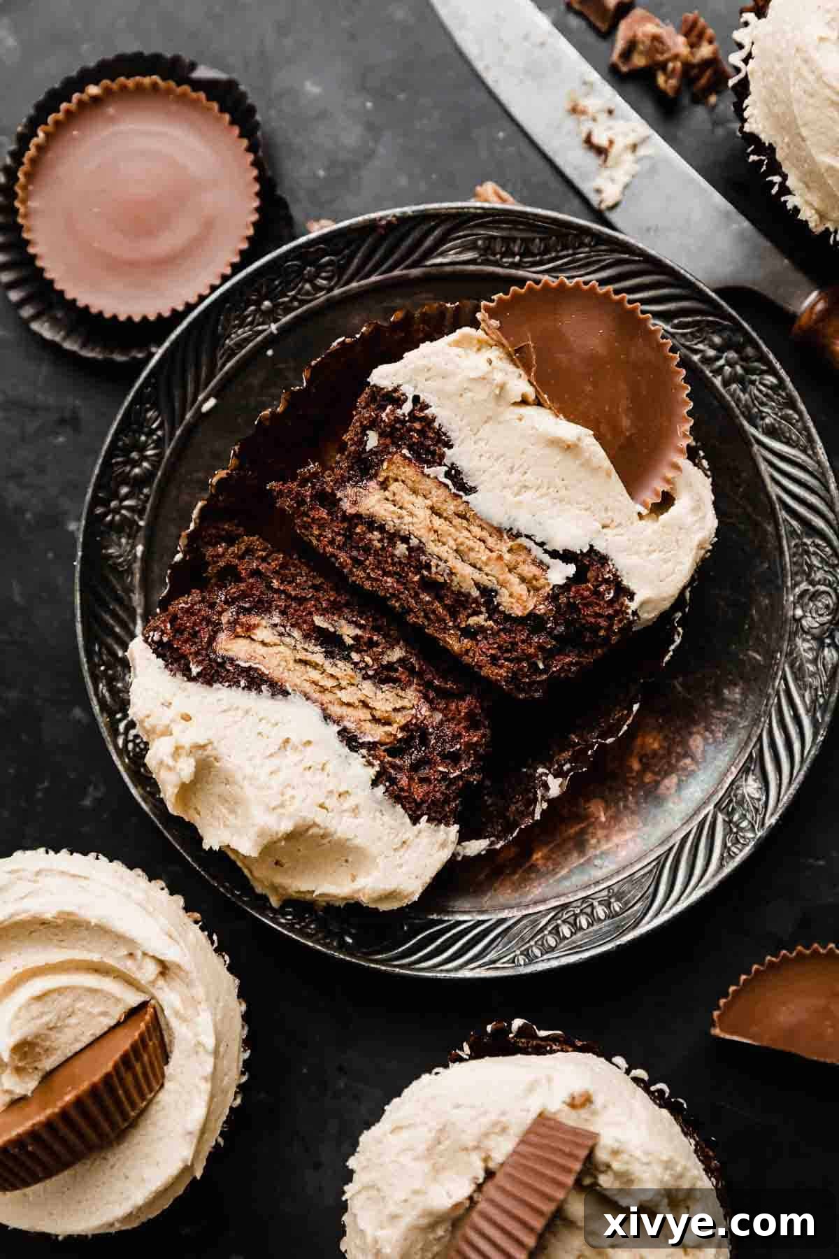 Reese's Peanut Butter Bliss Cupcakes 66 A Reeses Cupcake on an antique plate, cupcake cut in half showing that a reese's peanut butter cup was baked in the middle of the cupcake.