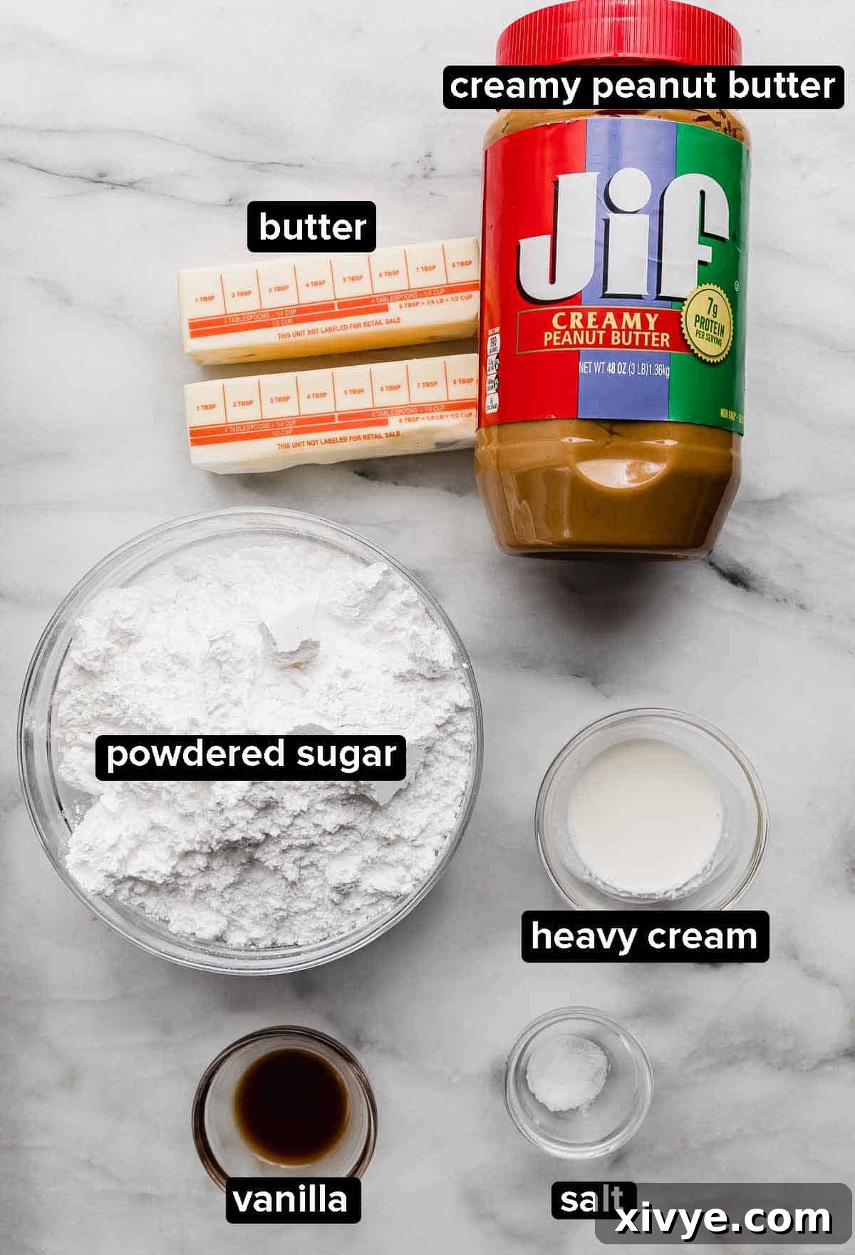 Peanut butter frosting ingredients on a white background: creamy peanut butter, butter, powdered sugar, salt, heavy cream, and vanilla.