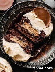 A Reese's Cupcake topped with peanut butter frosting and a Reese's peanut butter cup.