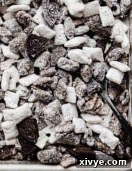 Oreo Muddy Buddies tossed with chopped Oreos on a baking sheet.