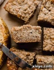 Banana Coffee Cake cut into squares with a yellowed banana next to the coffee cake.