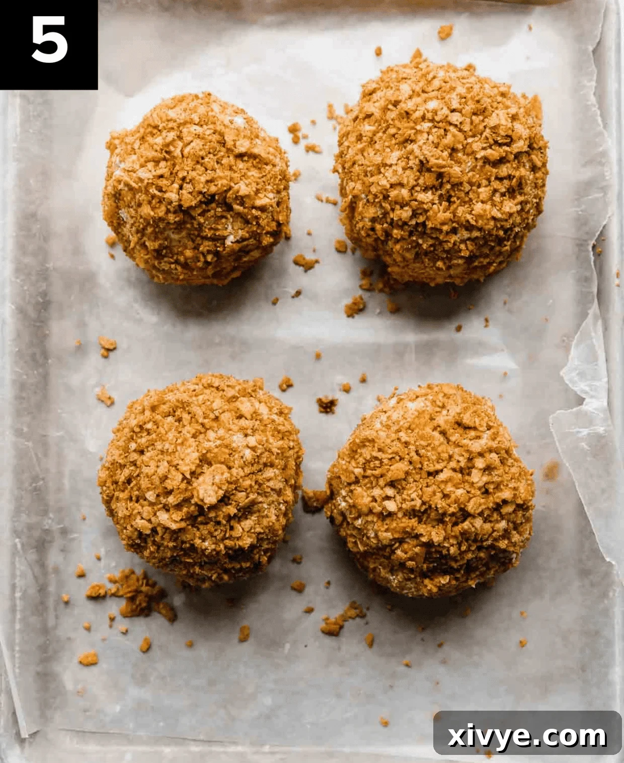 Golden Frost 5 4 No fry Fried Ice Cream balls covered in crushed cornflake cereal on a baking sheet.