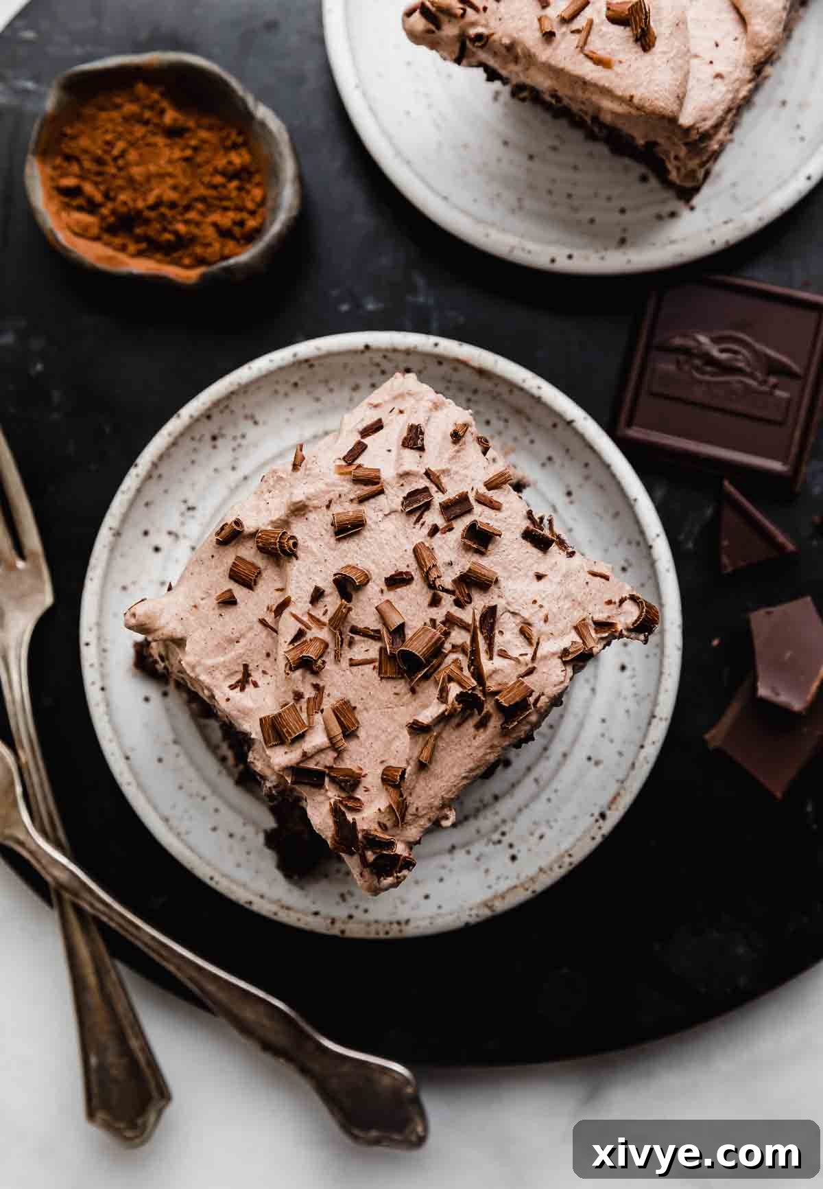 Heavenly Chocolate Tres Leches Cake 8 Overhead photo of Chocolate Tres Leches Cake topped with chocolate swirls on a black background.