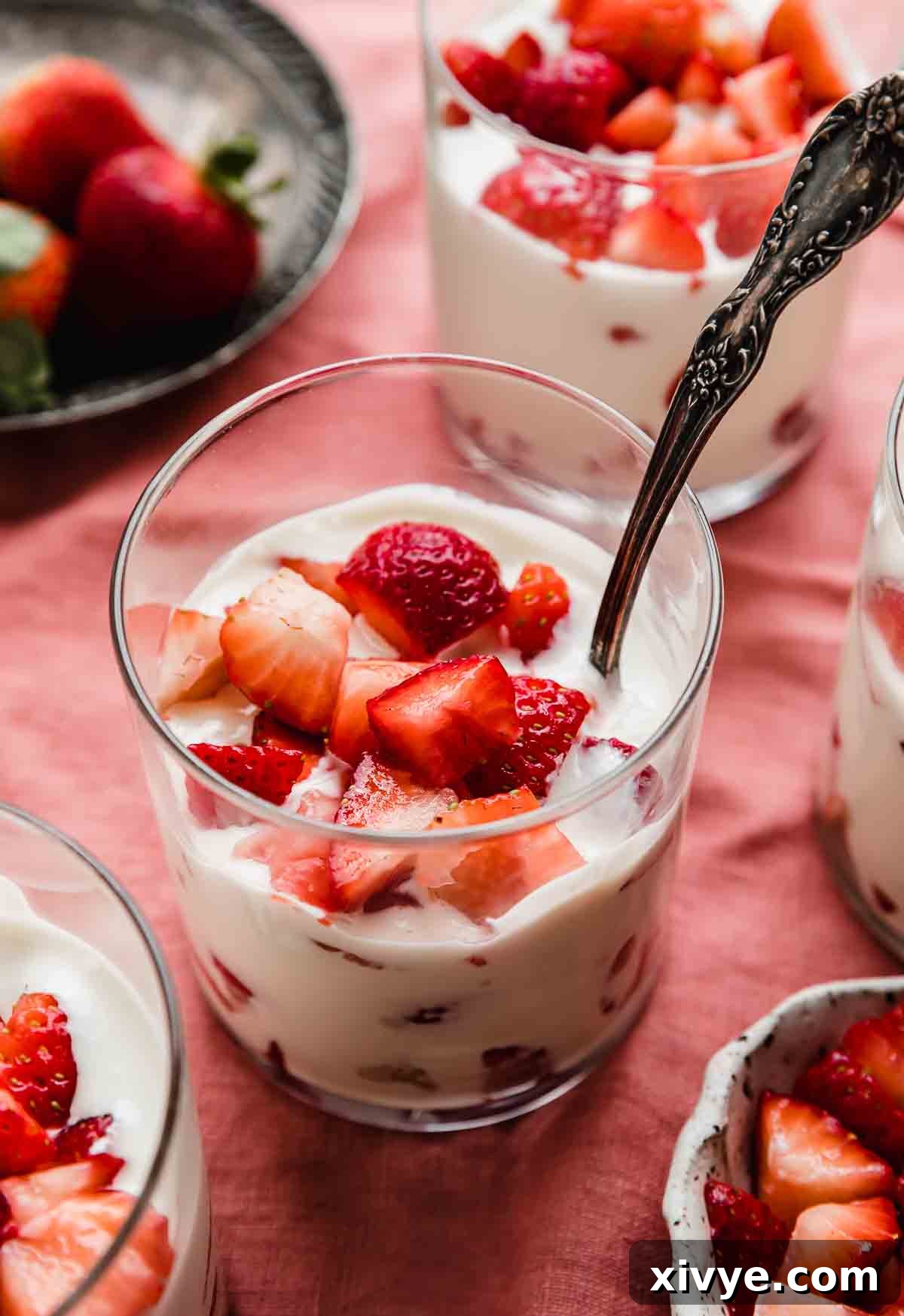 Creamy Strawberry Indulgence 2 A glass cup filled with Strawberries and Cream (Fresas con Crema), on a light red linen napkin.