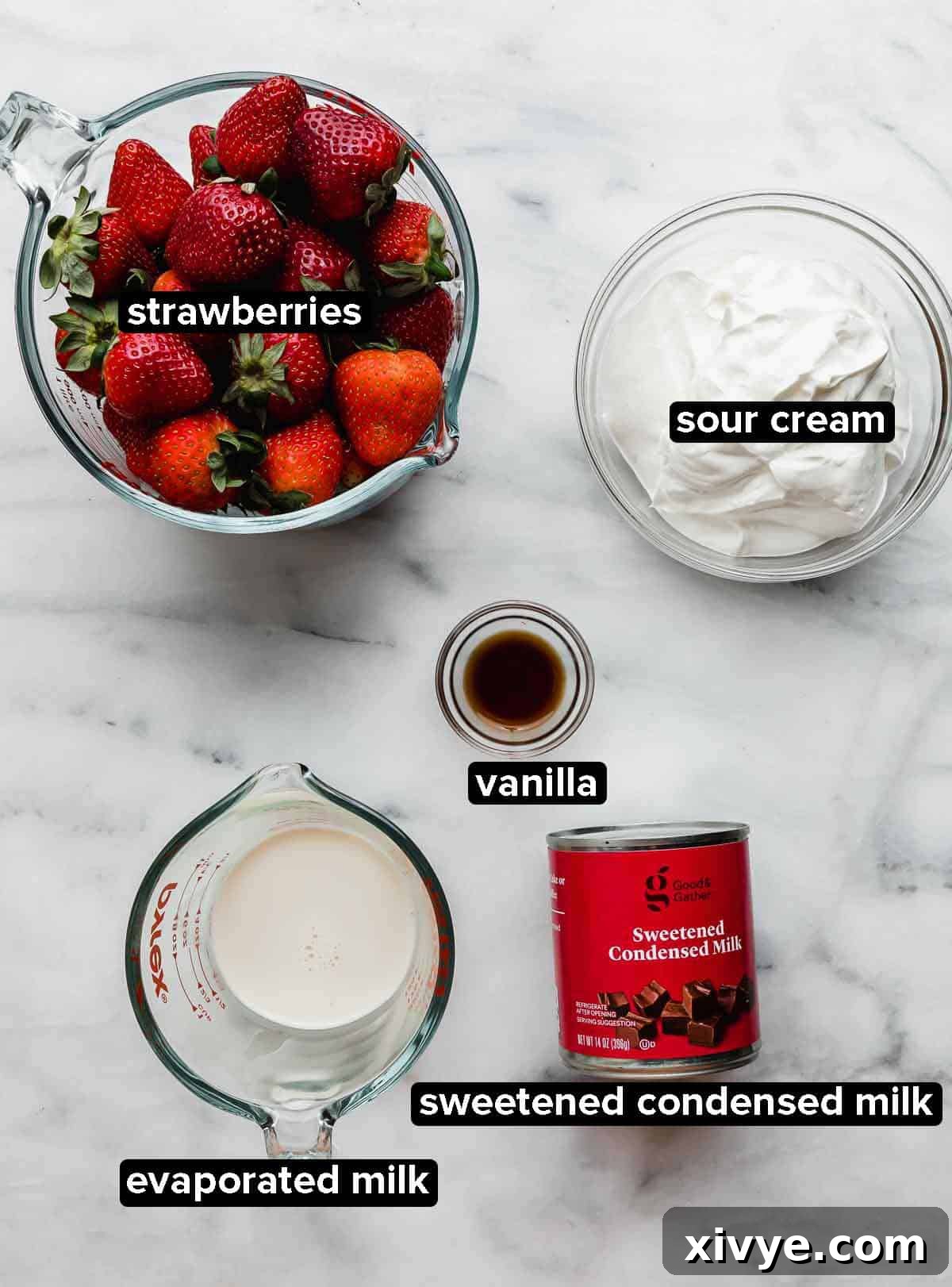 Creamy Strawberry Indulgence 3 Strawberries and Cream (Fresas con Crema) recipe ingredients portioned into glass bowls on a white and gray marbled background.