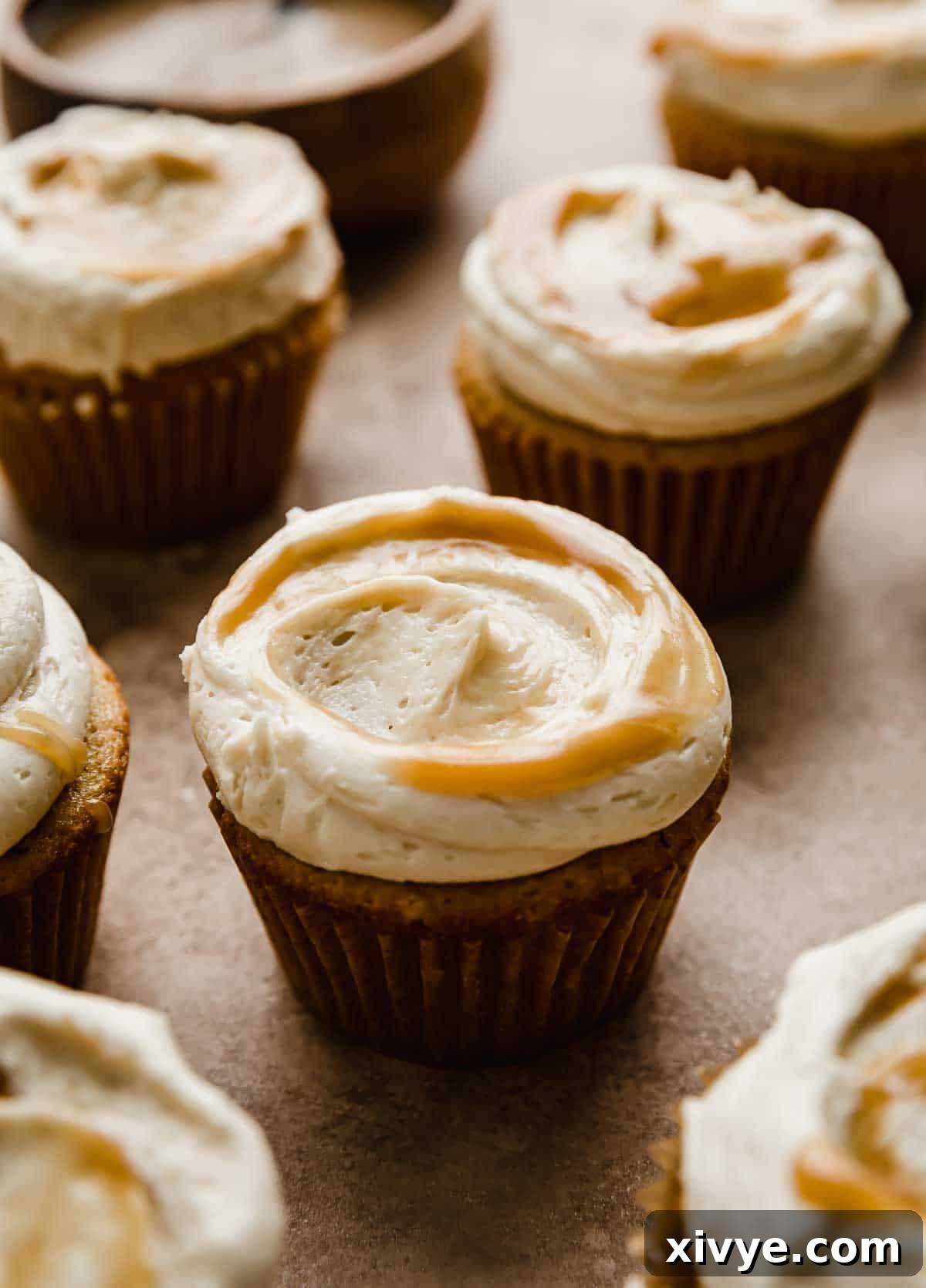 Golden Butterscotch Delights 2 A Butterscotch frosting covered brown butter cupcake on a light brown background.