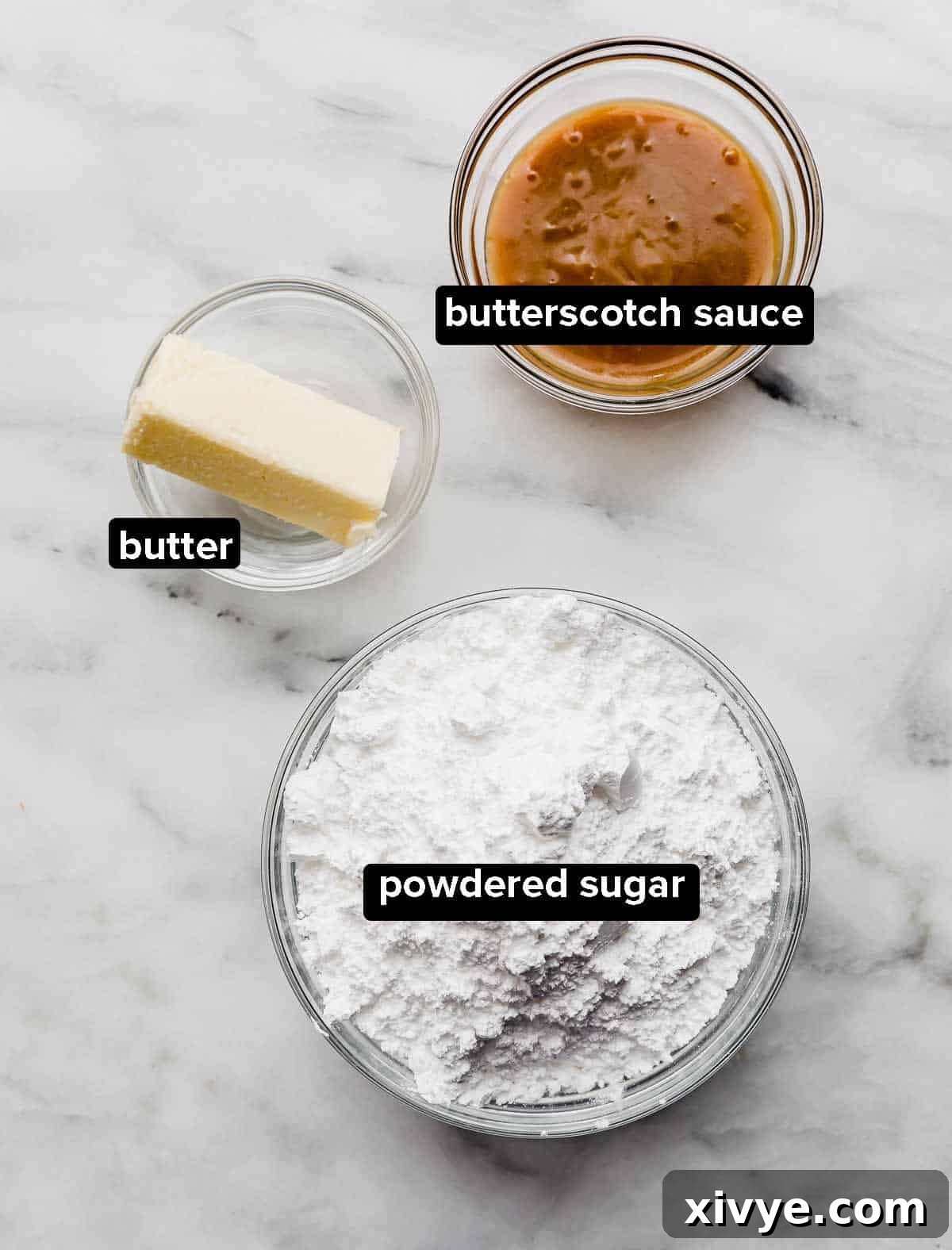 Golden Butterscotch Delights 4 Butterscotch Cupcakes frosting ingredients on a white marble table: powdered sugar, butterscotch sauce and butter.