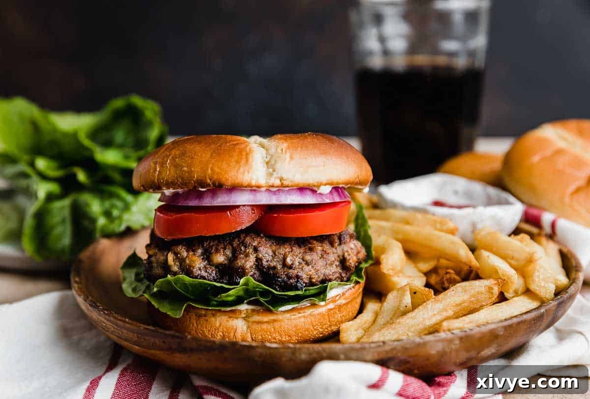 Signature Steakhouse Burgers 5 Steakhouse Burgers on a brown plate with French fries against a brown background.