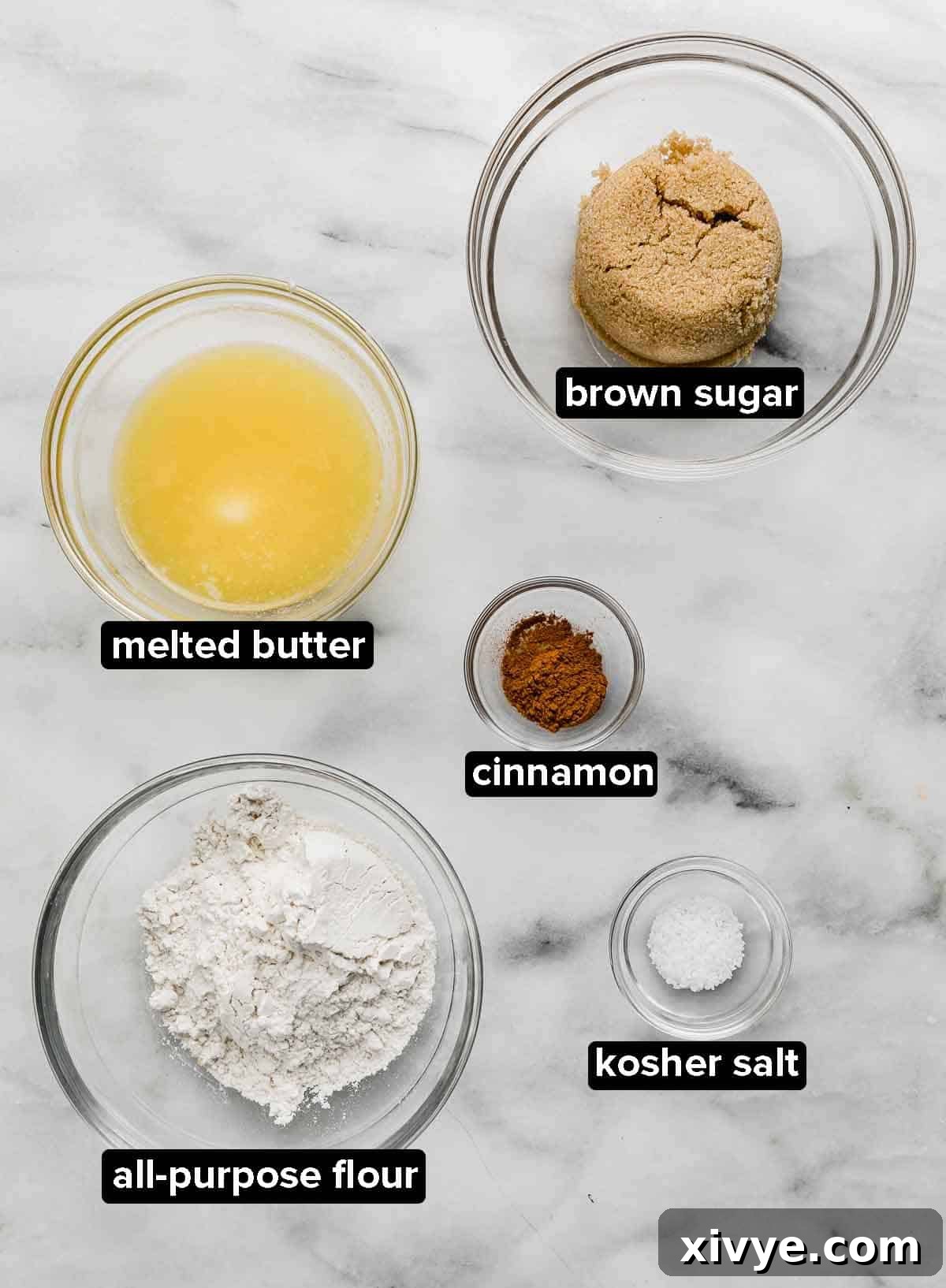 Autumn Apple Pie Graham Cracker Crunch 3 Butter, brown sugar, all-purpose flour, ground cinnamon, and kosher salt in separate glass bowls, essential ingredients for the crumble and filling of an Apple Pie with Graham Cracker Crust.