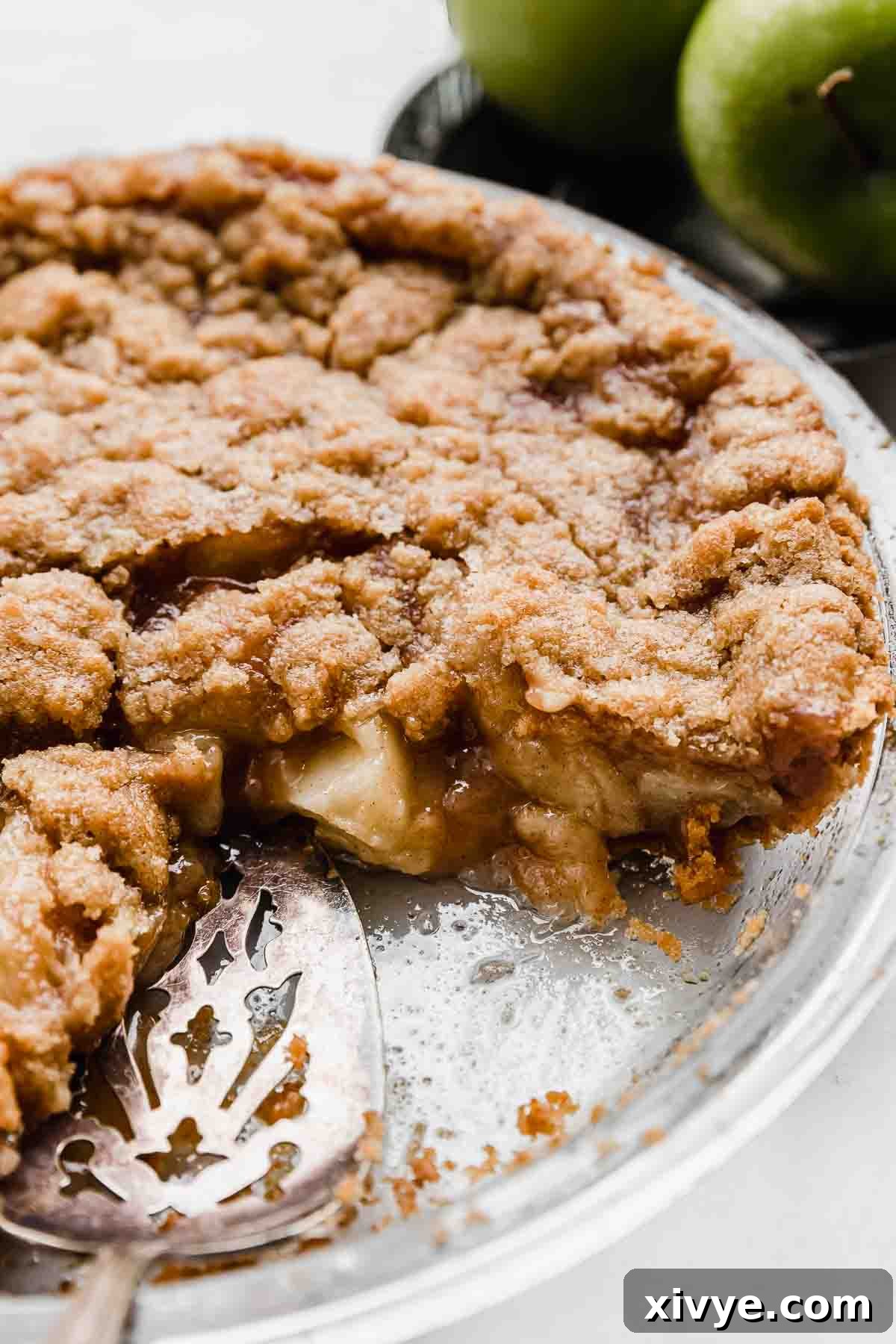 Autumn Apple Pie Graham Cracker Crunch 7 A perfectly baked Apple Pie with Graham Cracker Crust, cleanly sliced to reveal the layers of filling and crust, presented on a pristine white background.