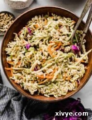 Crunchy broccoli slaw salad in a brown bowl on a white background.