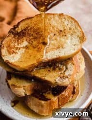 Artisan French Toast 8 French Bread French Toast with maple syrup overtop.