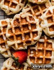 Belgian Liege Waffles with a fresh strawberry next to the waffle.