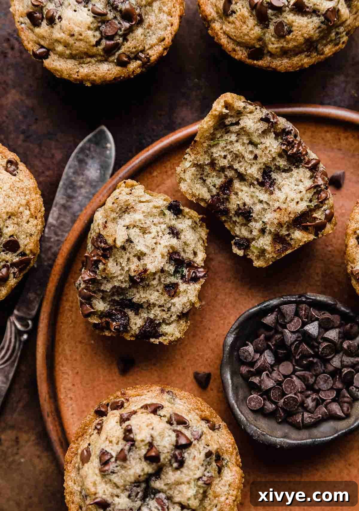 Garden Delight Chocolate Chip Muffins 7 A Zucchini Chocolate Chip Muffin cut in half on a brown plate.