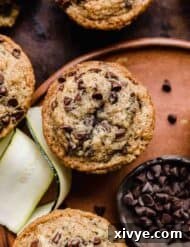 Garden Delight Chocolate Chip Muffins 8 Mini chocolate chip topped Zucchini Chocolate Chip Muffins on a brown plate.