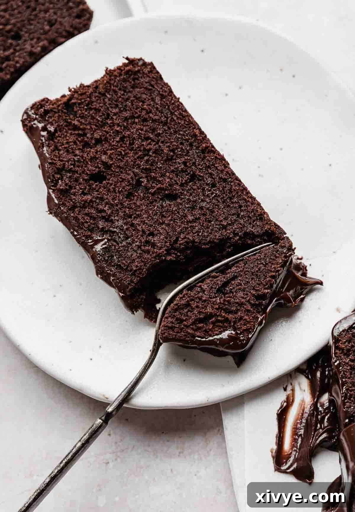 Slice of moist Chocolate Pound Cake on a white plate, highlighting its rich, dark interior.