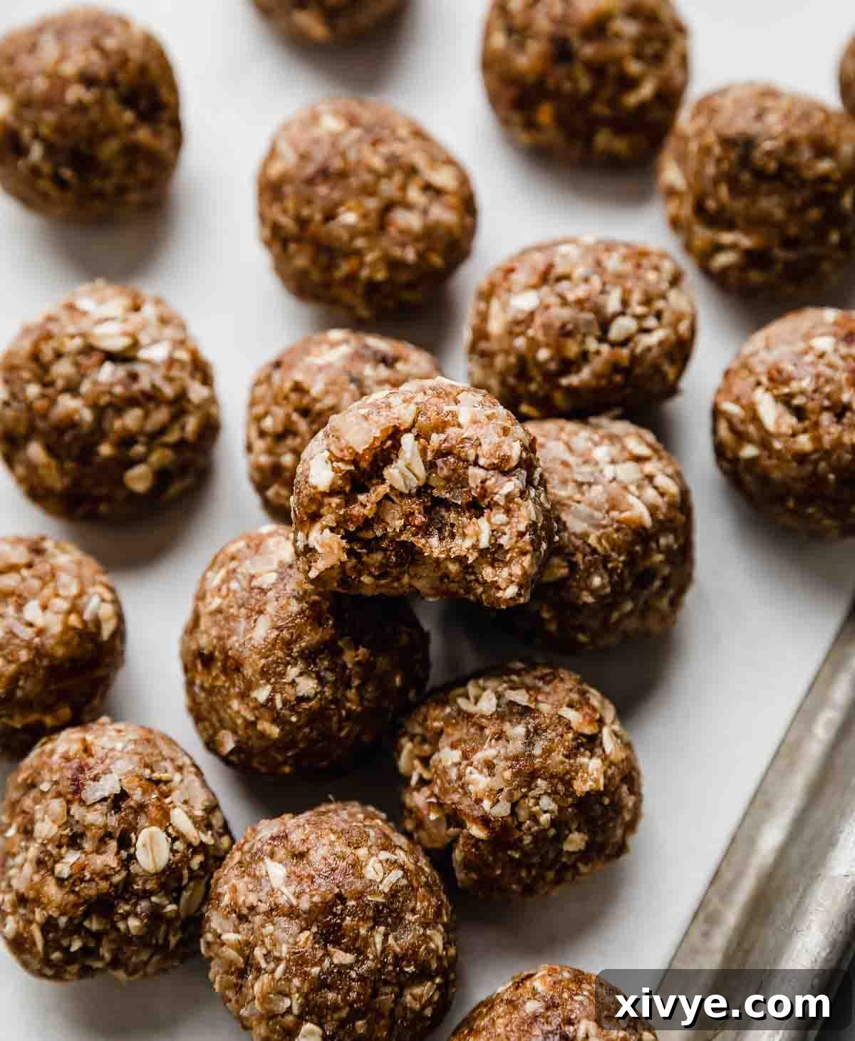 German Chocolate Protein Power Bites 5 German Chocolate Cake Protein Balls on a white parchment paper.