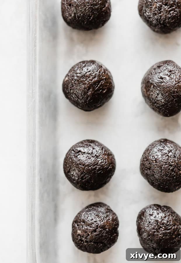 Spooktacular Halloween Oreo Truffles 6 Oreo balls lining a cookie sheet prior to dipping in chocolate.