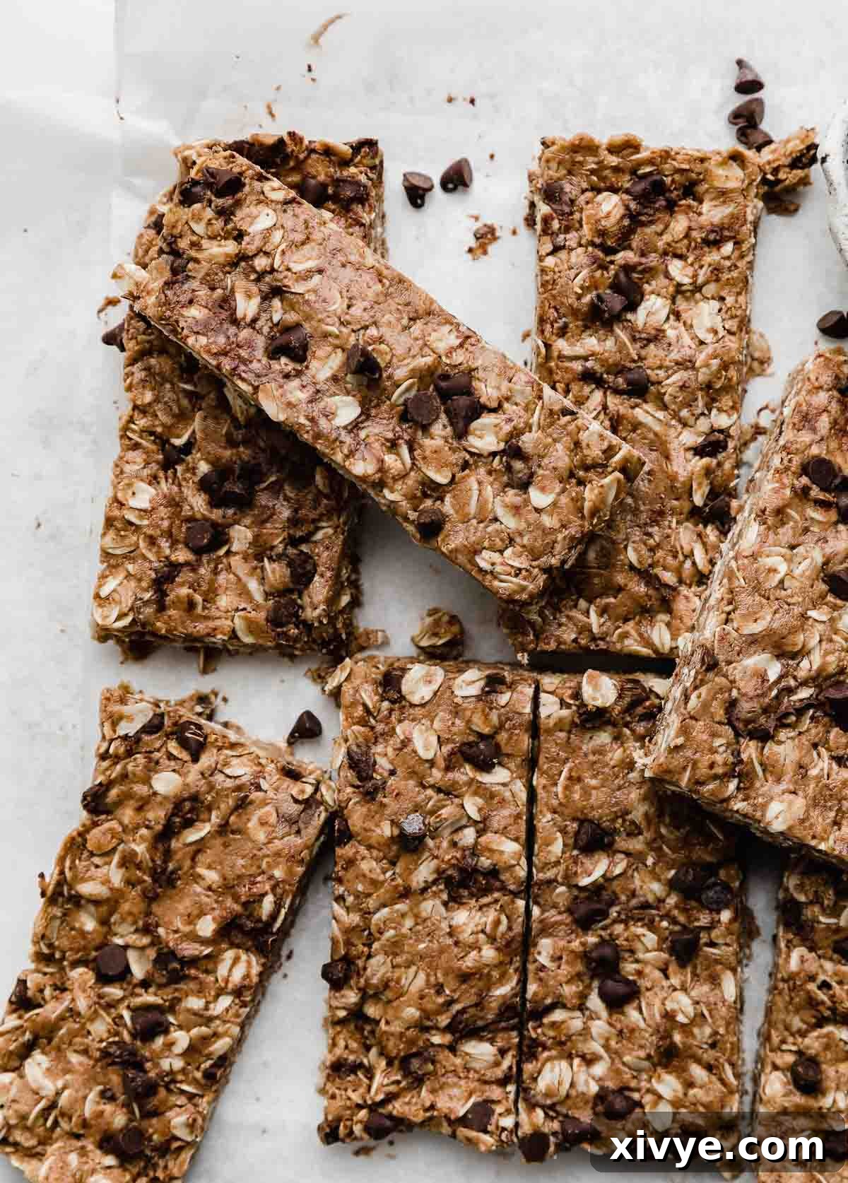 Irresistible Chocolate Peanut Butter Protein Bars 2 Irresistible homemade Chocolate Peanut Butter Protein Bars artfully arranged on crisp white parchment paper, showcasing their rich texture and readiness as a healthy, satisfying snack.