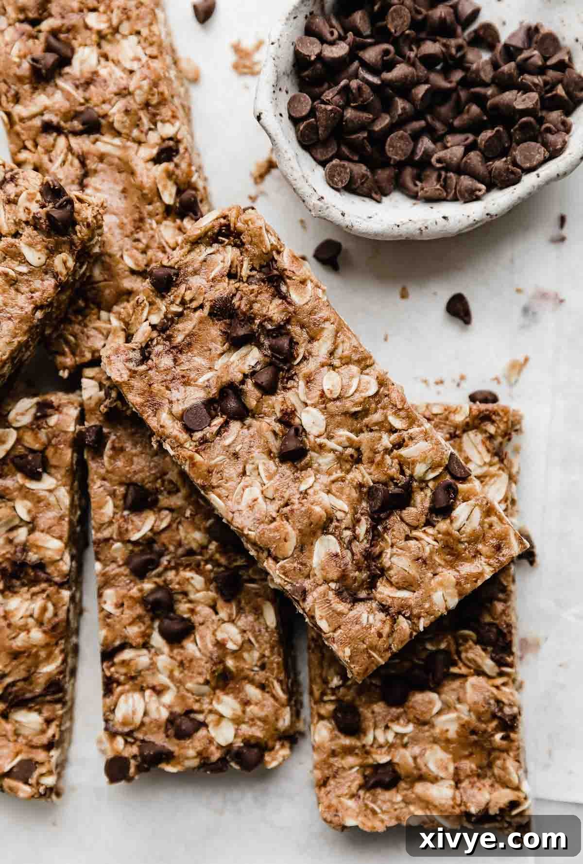 Irresistible Chocolate Peanut Butter Protein Bars 7 Perfectly portioned Chocolate Peanut Butter Protein Bars, elegantly topped with a generous sprinkle of mini chocolate chips, presented on a clean white background, highlighting their healthy appeal.