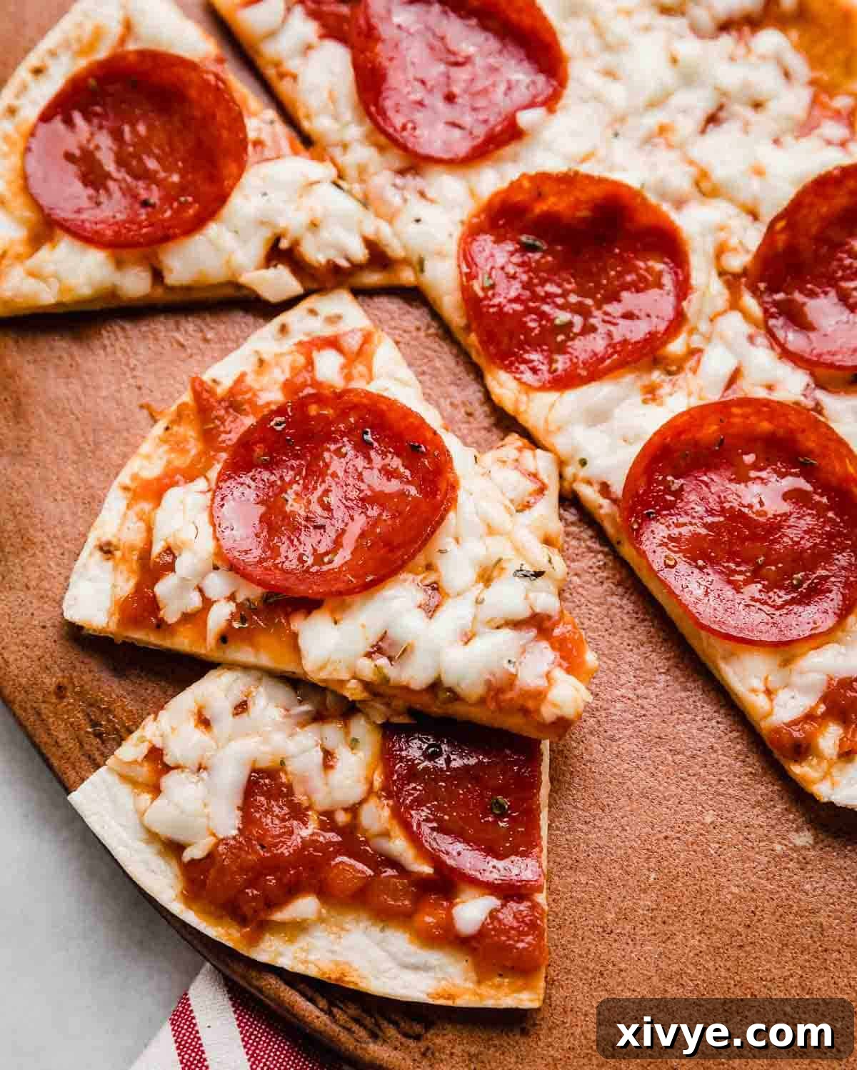 Tortilla Pizza cut into triangles on a brown plate.