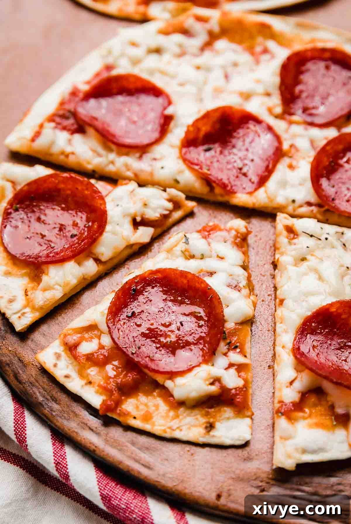 A Tortilla Pizza topped with pepperoni and sliced into triangles on a brown plate.