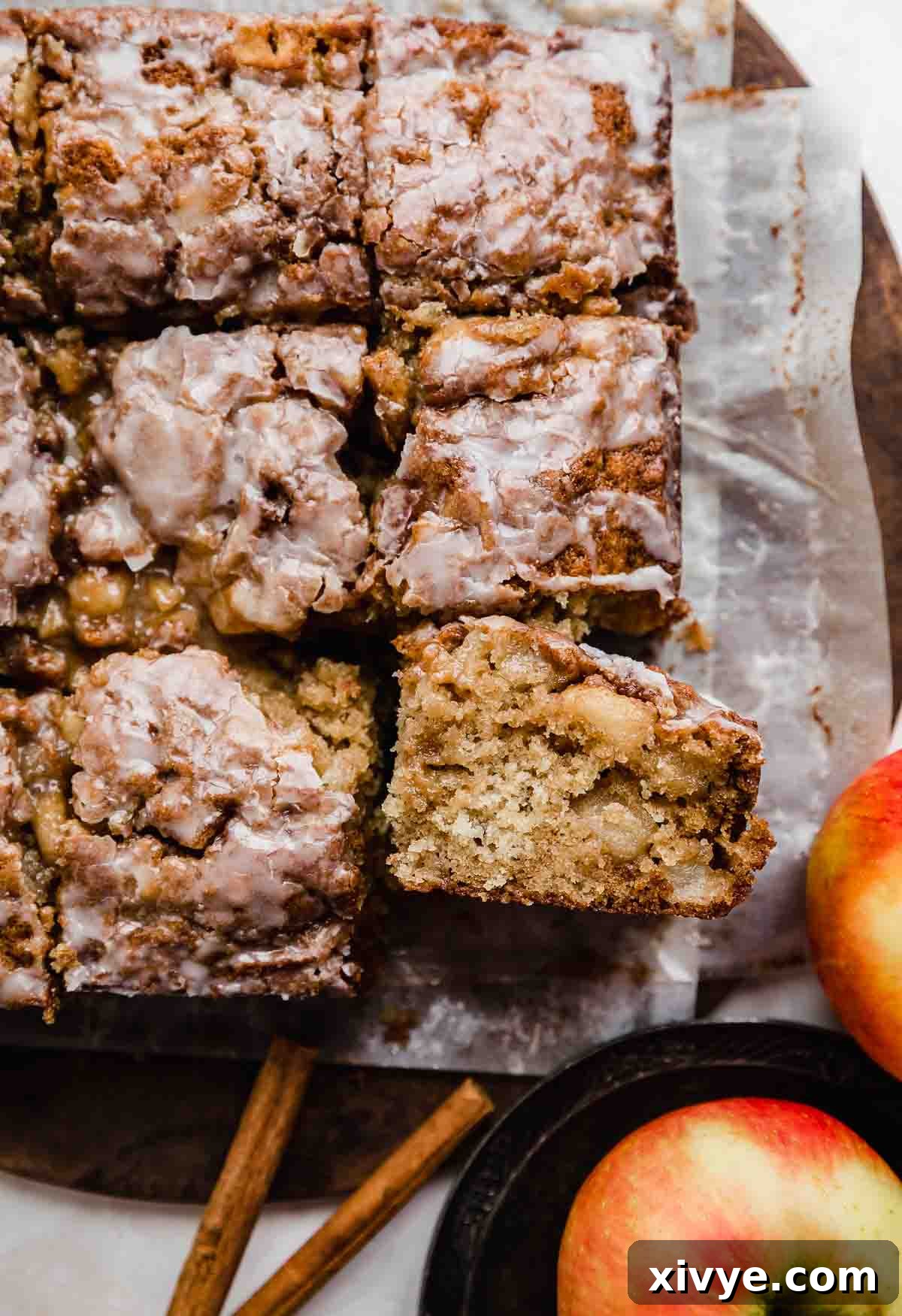 Spiced Apple Fritter Coffee Cake 2 An Apple Fritter Cake sliced into squares on parchment paper.