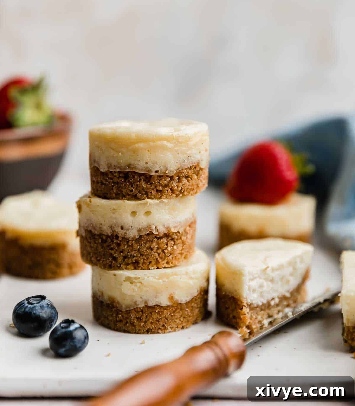 A stack of three baked mini cheesecakes against a white background.